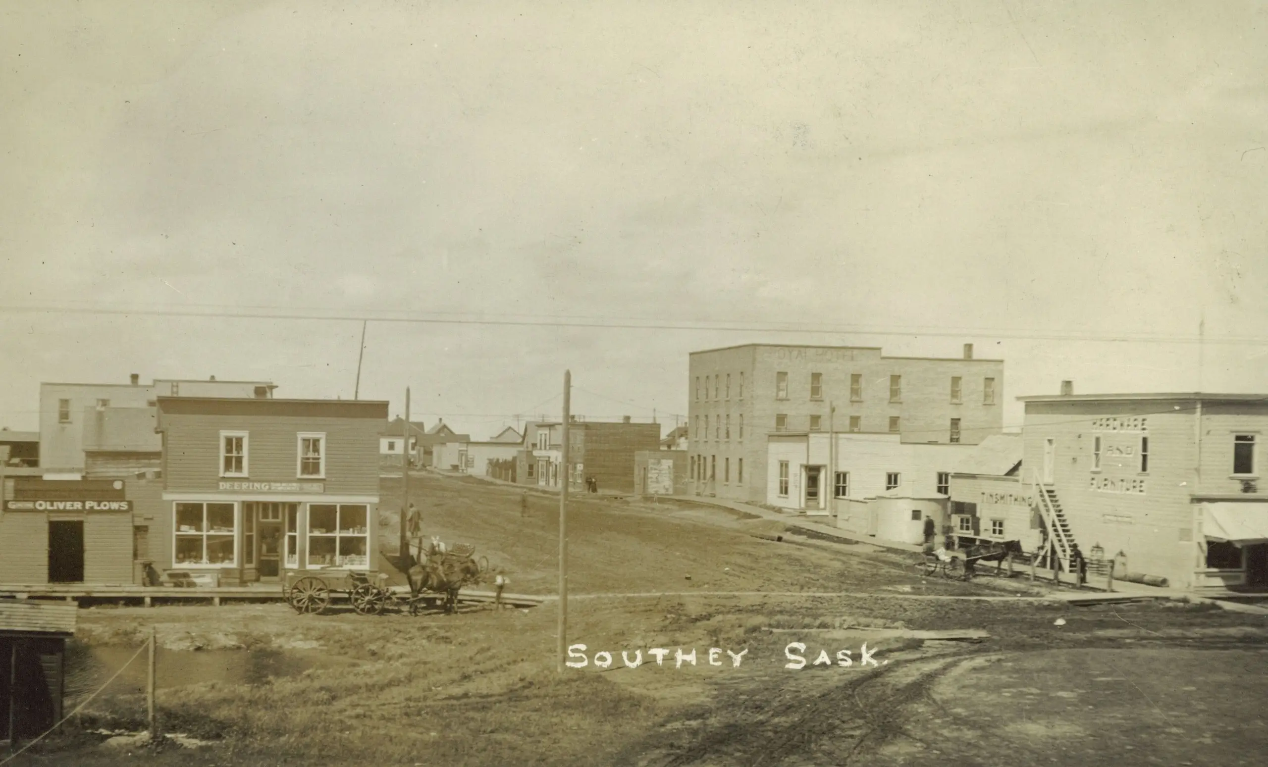 Street scene with early storefronts and horse-drawn wagons