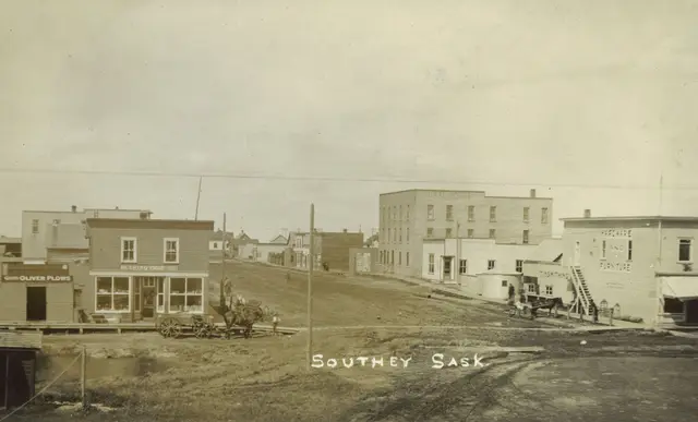 Street scene with early storefronts and horse-drawn wagons